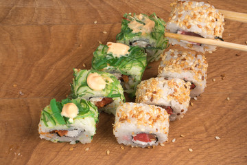 Sushi rolls on a wooden board (delicious food)