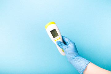 infrared non-contact temperature thermometer in hand, hand in glove, instantly measure temperature,...
