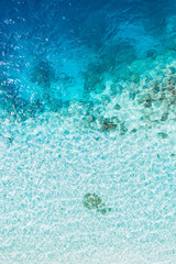 Background image of the turquoise sea. Deep sea and corals. Top view of beautiful Caribbean Sea. Aerial drone shot of turquoise water - space for text. Aquamarine background