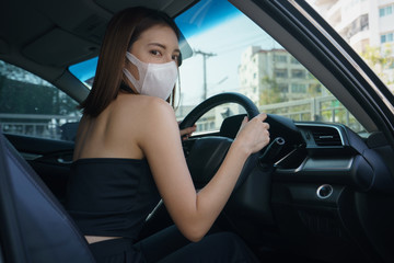 Wome wearing surgical mask in the car, for corona virus or Covid-19 protection.