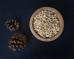 Pine nuts and pine cones against a black background