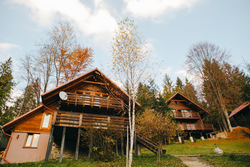 Obraz premium Cottage in a forest in autumn colors in a mountain landscape. The concept of mountain break, short trip, hiking.