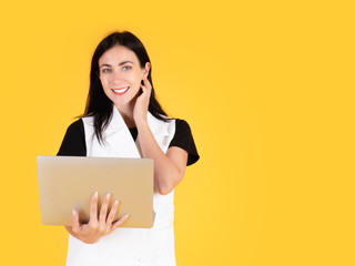 30s Caucasian businesswoman smile with hesitate gesture about asking boss to conference meeting when work from home while holding computer laptop digital device portrait isolated on yellow background