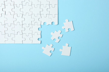 Fototapeta premium White puzzle on a colored background top view.