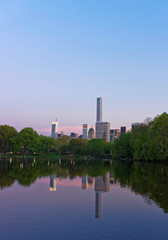 Manhattan skyline mirrored from water in Central Park