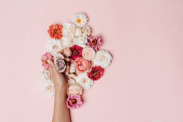 Fashion photo of hands and bright flowers on pink background. Concept of hand care.