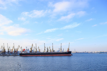 A large cargo ship stands on a pier in the port