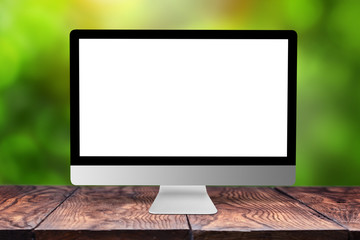 Mockup computer screen on wooden table against a blurred background.