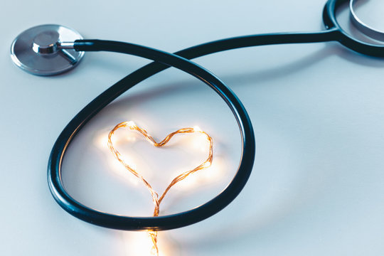 Cardiologo specializzato per operazioni chirurgiche al cuore. Concetto stilizzato con simbolo del cuore e stetoscopio su sfondo blu.