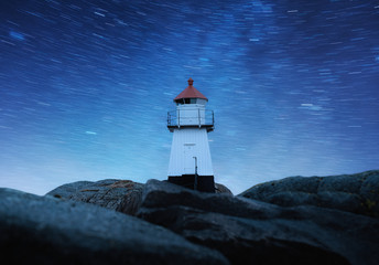 Lighthouse on the night sky background with stars. Landscape with lighthouse on the shore. Architecture at night. Travel - image