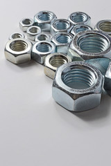 New chrome screw-nut of different sizes on a white background. Concept.
