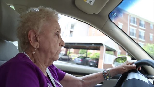 Elderly woman drives a car