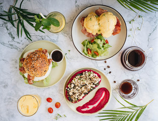 Lunch set of Benedict eggs toast, eggs burger and beetroot hummus toast served with lemonade, orange juice and coffee