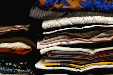 Colorful clothes folded in a closet. Selective focus.