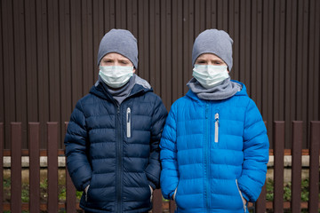 Children walking on the street in medical masks. Security and prevention of virus infection. Concept for the new Covid 19 Pirola Variant. 
