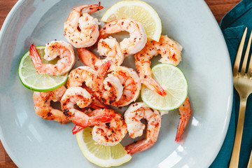Fried tiger shrimp with lime, lemon and spices on a ceramic dish. Healthy dinner or lunch concept.