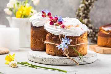 Easter Cake - Russian and Ukrainian Traditional Kulich or Brioche on a light stone background. Paska or Panettone Bread  and spring flowers