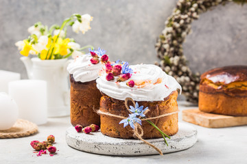 Easter Cake - Russian and Ukrainian Traditional Kulich or Brioche on a light stone background. Paska or Panettone Bread  and spring flowers