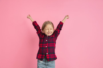 Crazy happy winner. Caucasian little girl's portrait on pink studio background. Beautiful female model with blonde hair. Concept of human emotions, facial expression, sales, ad, youth, childhood.