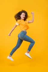 Fototapeta na wymiar Feel inner energy. Energetic woman running or jumping. Skinny jeans suits her. Sexy girl yellow background. Sensual girl in casual style. Pretty girl with long hair. Fashion style. Beauty and make up