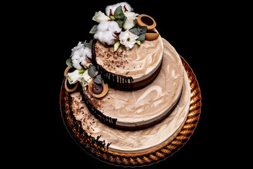  Raw vegan cake with chocolate, vanilla and peanut butter decorated with cotton, flowers and candy raw vegan toffee