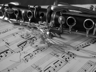Fototapeta premium Close up of a clarinet music instrument and music notes . Black and white photo .