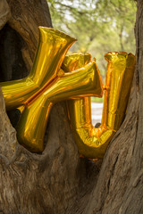 Metallic balloon inflatable with helium, gold color, with XV symbol, fifteen years concept, fifteenth anniversary