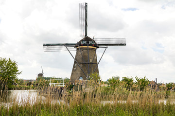 Fototapeta na wymiar Kinderdijk, Rotterdam, NETHERLANDS: Netherlands rural lanscape with windmills at famous tourist site Kinderdijk in Holland. Old Dutch village Kinderdijk, UNESCO world heritage site.