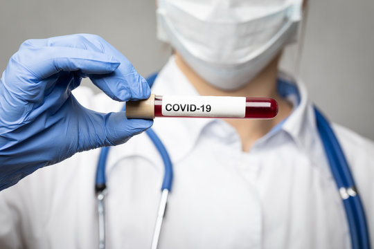 Doctor holding COVID-19 test or vaccine tube