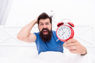 Get up right now. What time is it. Stressed man alarm clock. Sleepy man holding alarm clock in bed....