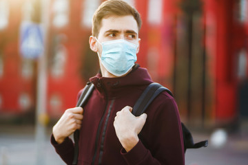 Portrait of men in protective sterile medical mask on her face on the street city. The concept of...