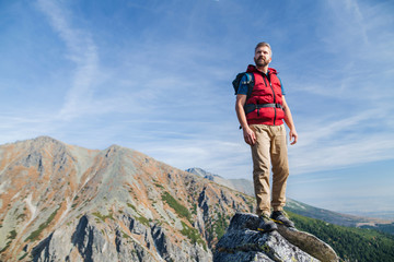Naklejka premium Mature man with backpack hiking in mountains in summer.