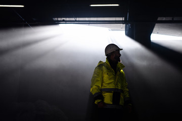 Man engineer standing on construction site. Copy space.