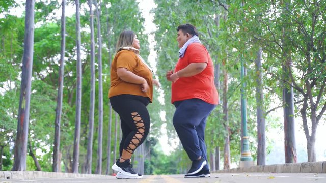 Obese man wiping his girlfriend sweats at park