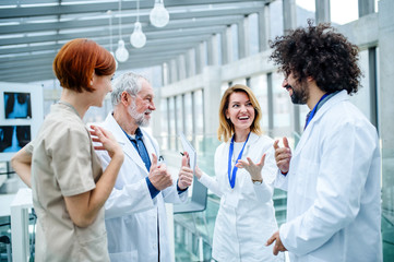 Group of doctors standing on conference, medical team laughing.