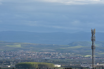 Obraz premium Telecommunications antenna with towns and the fertile plain of Granada in the background