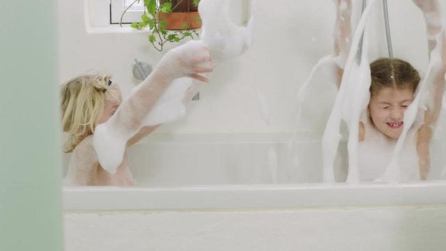 Brother And Sister Splashing Soap Suds In Bath