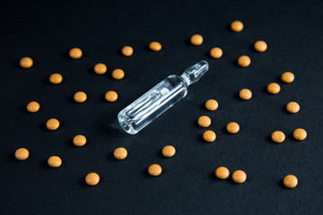 Coronavirus vaccine concept, cure for COVID-19. Pills and ampoule with drug against SARS-CoV-2.