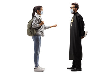 Female student talking to a priest, both wearing medical masks