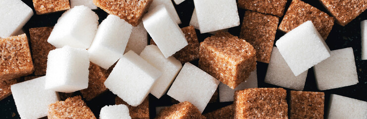 White and brown sugar cubes closeup. Panorama. View from above.