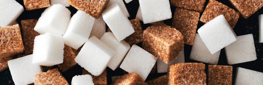 White And Brown Sugar Cubes Closeup. Panorama. View From Above.