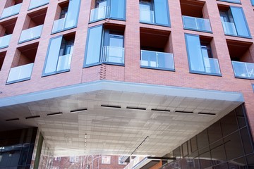 Fototapeta premium Exterior of new apartment buildings on a blue cloudy sky background. No people. Real estate business concept.