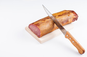 Delicious smoked meat on a wooden board isolated on white background.Copy space
