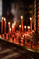 long lighted candles group in orthodox church. candles background. selective focus