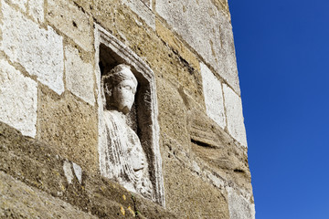 Antigua estatua en piedra incrustada en el muro del templo