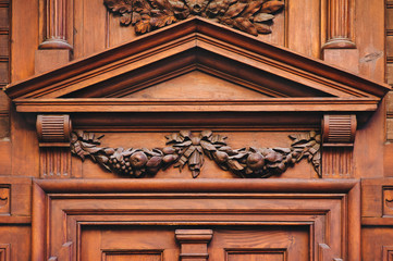 Antique luxury wooden door surrounded by handmade decor and carvings. Mahogany, portal to an ancient building.