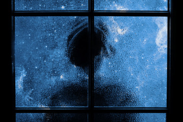Dark silhouette of child alone in isolation behind glass door. Abstract image of sadness, apathy,...