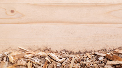 Wood chips biomass arranged in stripes on bottom of image on wood spruce background. Top view with copy space. Flat lay.