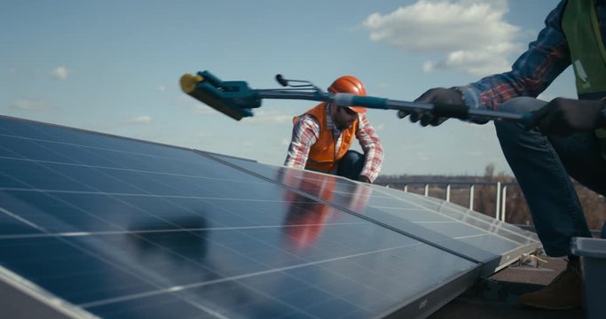 Technicians cleaning and maintaining solar panels