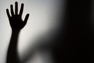 Blurred Woman's hand shadow asking for help. Horror and domestic violence concept - obrazy, fototapety, plakaty